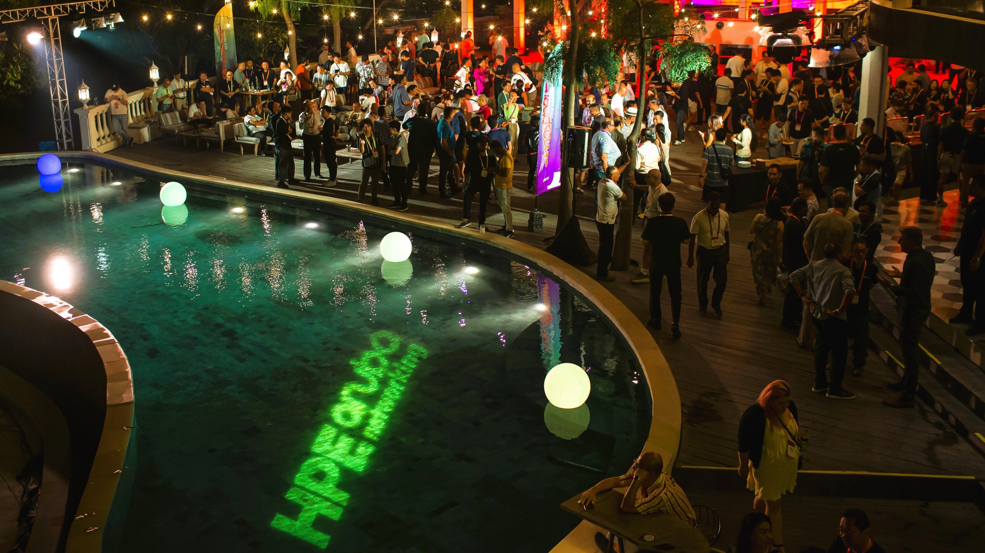 Atmosphere-23-Asia Pacific-Japan-PMG-5.jpg Atmosphere '23 attendees at a nighttime pool party, surrounded by colorful lights and a festive atmosphere.